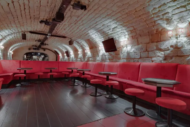 Salle principale : banquettes velours rouge et tabourets dorés