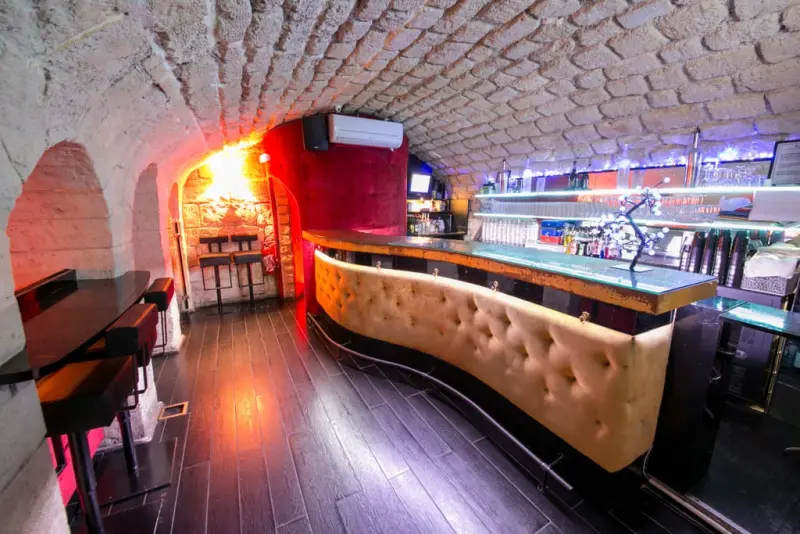 Le bar du Lieu Secret en cuir capitonné, sous les voûtes en pierre